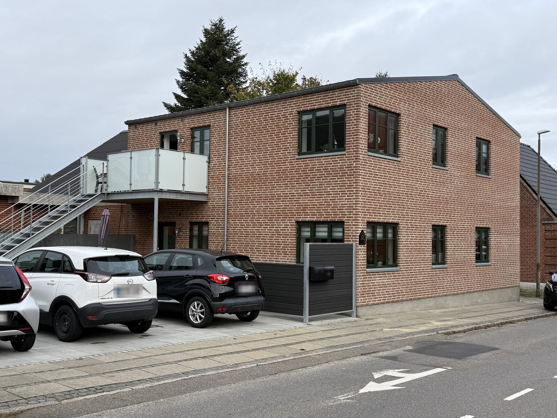 Det færdige hus med to lejligheder i rød blank mur, udvendig trappe og altan